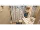 Cozy bathroom featuring a vanity sink, toilet, and a shower with a blue and white curtain at 3390 Ramblewood Ct, Sarasota, FL 34237