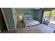 Bright bedroom features wood-look floors, a ceiling fan, sliding glass doors to a patio, and coastal decor at 3390 Ramblewood Ct, Sarasota, FL 34237