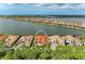 The home featured is lakeside with a tiled roof, lush landscaping, and tranquil water views at 344 Maraviya Blvd, Nokomis, FL 34275
