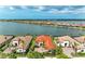 Stunning aerial view of waterfront homes with red tile roofs and lush landscaping overlooking a serene lake at 344 Maraviya Blvd, Nokomis, FL 34275
