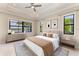 Serene bedroom with tray ceiling, ceiling fan, neutral walls, and large windows offering peaceful backyard views at 344 Maraviya Blvd, Nokomis, FL 34275