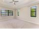 Bright, carpeted bedroom with large windows and ceiling fan is a relaxing retreat at 344 Maraviya Blvd, Nokomis, FL 34275