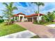 Beautiful Mediterranean-style home featuring a paver driveway, lush landscaping, and a three-car garage at 344 Maraviya Blvd, Nokomis, FL 34275