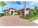 Mediterranean-style home with a well-manicured lawn, paver driveway, and lush tropical landscaping at 344 Maraviya Blvd, Nokomis, FL 34275