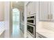 Gourmet kitchen boasts stainless steel appliances and gray cabinetry, complemented by a tiled backsplash at 344 Maraviya Blvd, Nokomis, FL 34275