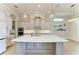 Bright kitchen boasts a large island with quartz countertops, stainless appliances, and designer fixtures at 344 Maraviya Blvd, Nokomis, FL 34275