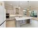Gourmet kitchen with a large island, stylish pendant lights, and stainless steel appliances at 344 Maraviya Blvd, Nokomis, FL 34275