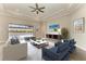 Staged living room with neutral furniture, a ceiling fan, and sliding glass doors leading to the outdoor area at 344 Maraviya Blvd, Nokomis, FL 34275