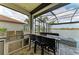 An outdoor kitchen with a stainless steel grill and bar seating overlooks a serene lake view at 344 Maraviya Blvd, Nokomis, FL 34275