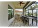 A covered outdoor kitchen features stainless steel appliances, counter seating, and a view of the backyard at 344 Maraviya Blvd, Nokomis, FL 34275