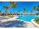 Resort-style pool area featuring palm trees, a spacious deck, and inviting lounge chairs on a sunny day at 344 Maraviya Blvd, Nokomis, FL 34275