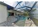 The screened lanai features a pool, spa, and outdoor kitchen overlooking a serene lake, perfect for entertaining at 344 Maraviya Blvd, Nokomis, FL 34275