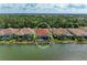 Back of home overlooking lake; highlighting a screened in lanai with pool and spa, and the lake view beyond at 344 Maraviya Blvd, Nokomis, FL 34275