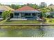 Tranquil waterfront view of a home with a screened-in lanai, pool, and spa, set against a serene lake backdrop at 344 Maraviya Blvd, Nokomis, FL 34275
