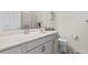 Bathroom vanity with gray cabinets, a white countertop, and decorative finishes, including a framed mirror at 3736 82Nd Avenue E Cir # 104, Sarasota, FL 34243