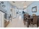 Bright dining area with modern lighting and an open layout leading to the kitchen at 3736 82Nd Avenue E Cir # 104, Sarasota, FL 34243