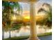 Picturesque sunset view overlooking a serene lake framed by palm trees and elegant architectural elements at 3736 82Nd Avenue E Cir # 104, Sarasota, FL 34243