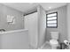 Clean bathroom featuring a white shower curtain, framed window and tile flooring at 3857 Woodrow Ridge St, Sarasota, FL 34233