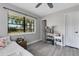 Bright bedroom featuring a large window, modern gray floors, and neutral decor at 3857 Woodrow Ridge St, Sarasota, FL 34233