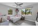 Charming bedroom featuring large windows, ceiling fan, modern gray floors, and soft decor at 3857 Woodrow Ridge St, Sarasota, FL 34233
