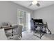 Office/bedroom offering neutral walls, a ceiling fan, sliding glass door and modern gray flooring at 3857 Woodrow Ridge St, Sarasota, FL 34233