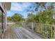 Wooden deck with gray railings overlooking lush landscaping and mature trees at 3857 Woodrow Ridge St, Sarasota, FL 34233