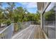 Wooden deck with gray railings overlooking lush landscaping and mature trees at 3857 Woodrow Ridge St, Sarasota, FL 34233