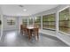 Spacious dining room with ample natural light, gray floors, and a large wooden dining table at 3857 Woodrow Ridge St, Sarasota, FL 34233
