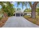 Two-car garage exterior with a long driveway, and well-maintained lawn at 3857 Woodrow Ridge St, Sarasota, FL 34233