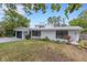 Home exterior with a covered parking area, well-kept lawn, and tidy landscaping at 3857 Woodrow Ridge St, Sarasota, FL 34233