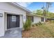 Home's front entrance featuring a decorative door, manicured landscaping, and window at 3857 Woodrow Ridge St, Sarasota, FL 34233