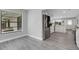 Bright kitchen featuring stainless steel appliances, white cabinetry, and modern gray flooring at 3857 Woodrow Ridge St, Sarasota, FL 34233