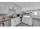 Stylish kitchen with white cabinetry, granite countertops, stainless steel appliances, and modern hardware at 3857 Woodrow Ridge St, Sarasota, FL 34233