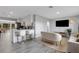 Bright, open-concept living area featuring a modern kitchen with a breakfast bar and views into a cozy, furnished seating area at 3857 Woodrow Ridge St, Sarasota, FL 34233