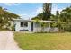 Charming home with light blue siding, white trim, covered porch, and a well-maintained front yard at 4111 Rockefeller Ave, Sarasota, FL 34231