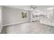 Spacious living room with a view into the adjacent kitchen, featuring light gray walls and modern flooring at 4111 Rockefeller Ave, Sarasota, FL 34231