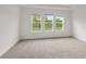 Bright bedroom featuring a large window overlooking the landscaped yard at 4240 Pond Brook Ct, Bradenton, FL 34211
