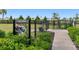 Community dog park with fenced-in area, signage, and walking path with green shrubs at 4240 Pond Brook Ct, Bradenton, FL 34211