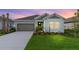 Charming single-story home boasting a well-manicured lawn, two-car garage, and inviting curb appeal at sunset at 4240 Pond Brook Ct, Bradenton, FL 34211