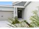 Inviting front entry with a black door, sidelight, and manicured landscaping details at 4240 Pond Brook Ct, Bradenton, FL 34211