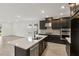 Bright kitchen with an island and dark cabinets, stainless steel appliances, and an adjacent living area at 4240 Pond Brook Ct, Bradenton, FL 34211