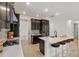 Modern kitchen features a large island with seating, stainless steel appliances, and elegant dark wood cabinetry at 4240 Pond Brook Ct, Bradenton, FL 34211