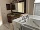 Bathroom shows a granite countertop vanity, a large mirror, updated cabinets, and a walk-in tub at 4538 Hamlets Grove Dr, Sarasota, FL 34235