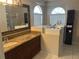 Bathroom features a walk-in tub, granite countertop vanity, and a large mirror, creating a spa-like retreat at 4538 Hamlets Grove Dr, Sarasota, FL 34235
