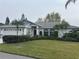 Charming single-story home with a well-manicured front lawn, landscaping, and an attached two-car garage at 4538 Hamlets Grove Dr, Sarasota, FL 34235