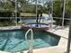 Heated spa attached to the pool in screened in lanai with water feature in the background at 4538 Hamlets Grove Dr, Sarasota, FL 34235