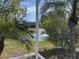 Screened-in back porch view overlooking a serene pond with fountain and lush landscaping at 4538 Hamlets Grove Dr, Sarasota, FL 34235