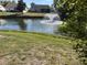 Backyard view overlooking a serene pond with fountain and lush landscaping at 4538 Hamlets Grove Dr, Sarasota, FL 34235