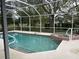 Screened-in pool and hot tub in backyard with a view of the water and fountain at 4538 Hamlets Grove Dr, Sarasota, FL 34235