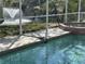 Outdoor pool with connecting spa under screen, overlooking a backyard pond with a fountain at 4538 Hamlets Grove Dr, Sarasota, FL 34235